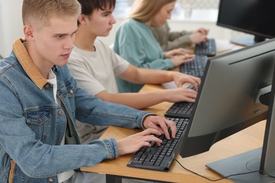 Photo of Students taking online exam indoors, selective focus