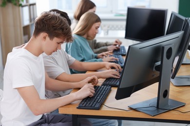 Photo of Students taking online exam indoors, selective focus