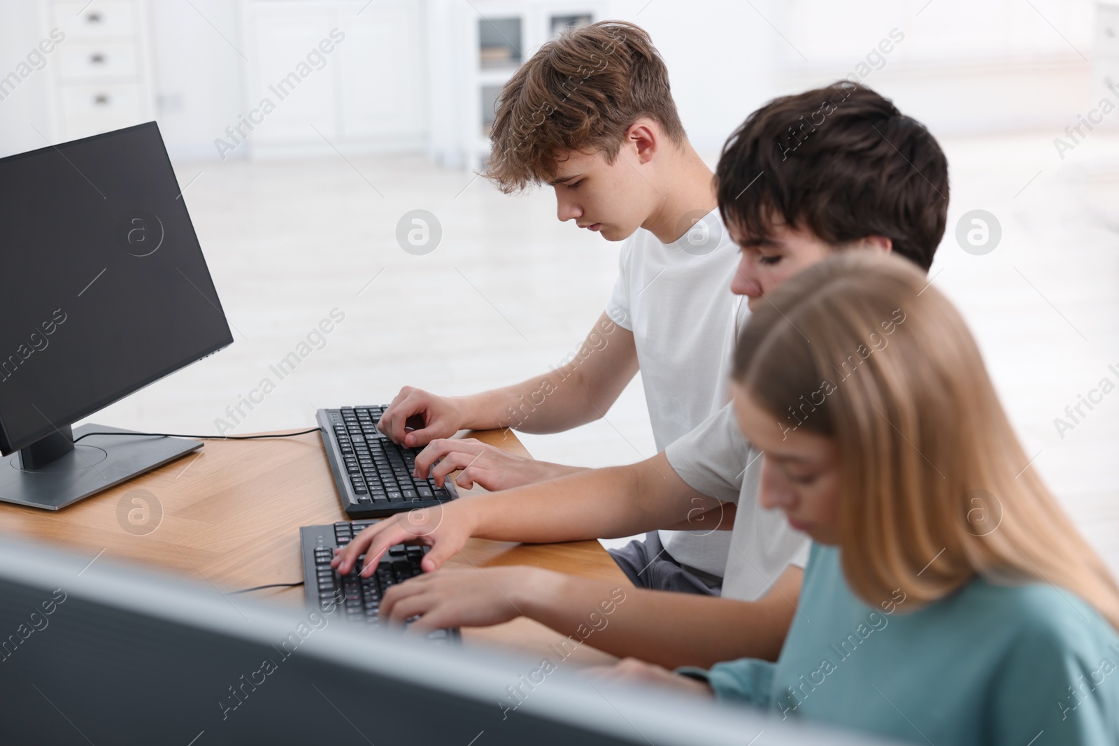 Photo of Students taking online exam indoors, selective focus