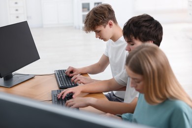 Photo of Students taking online exam indoors, selective focus