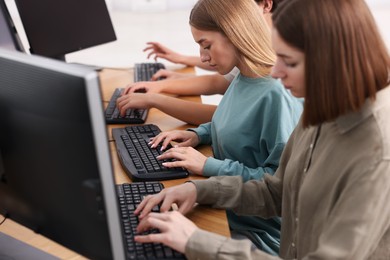Photo of Students taking online exam indoors, selective focus
