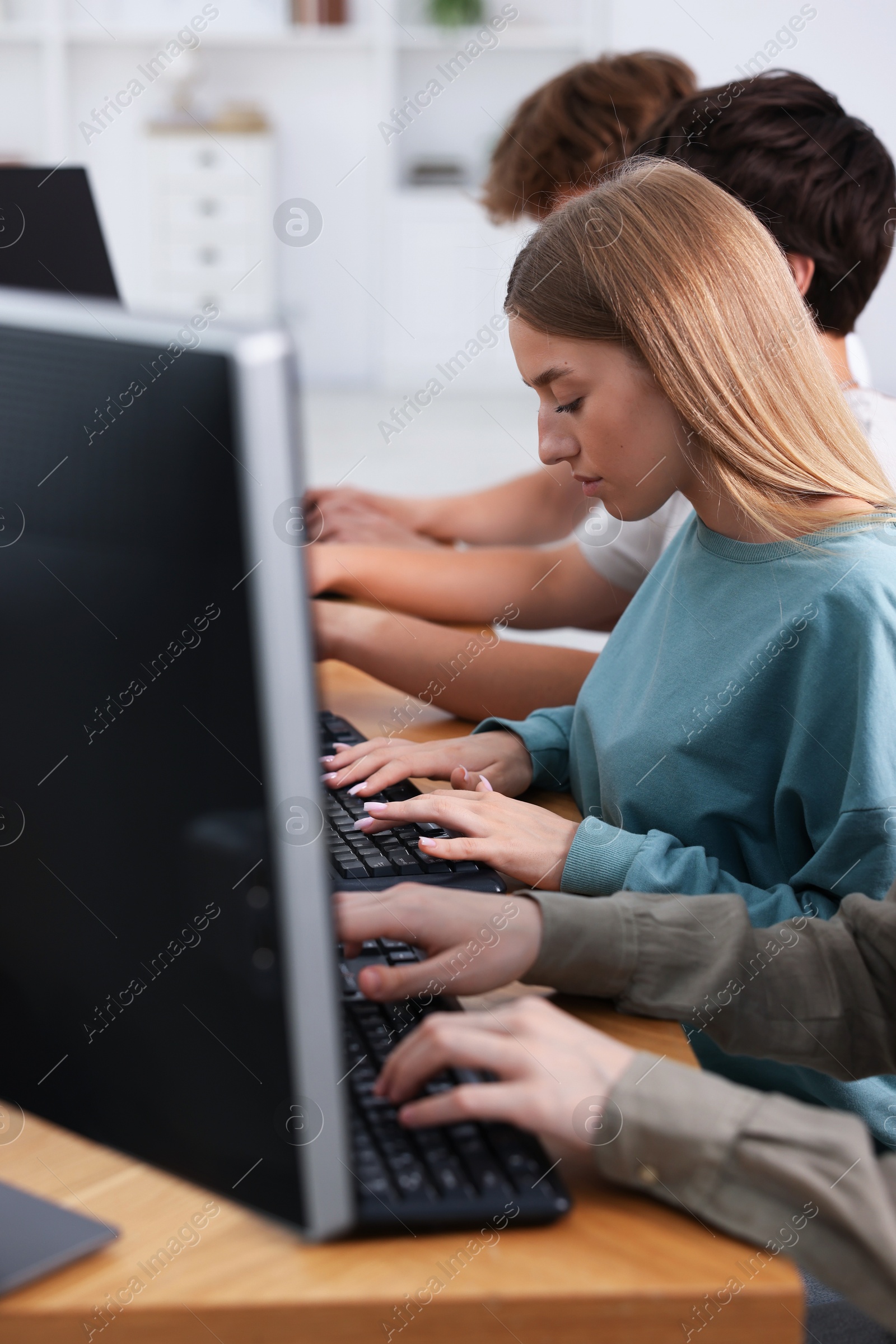 Photo of Students taking online exam indoors, selective focus
