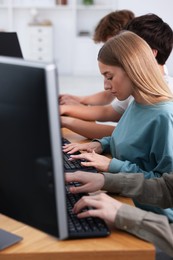 Photo of Students taking online exam indoors, selective focus