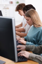 Photo of Students taking online exam indoors, selective focus