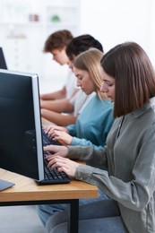 Photo of Students taking online exam indoors, selective focus