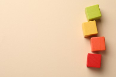 Photo of Colorful cubes on beige background, flat lay. Space for text
