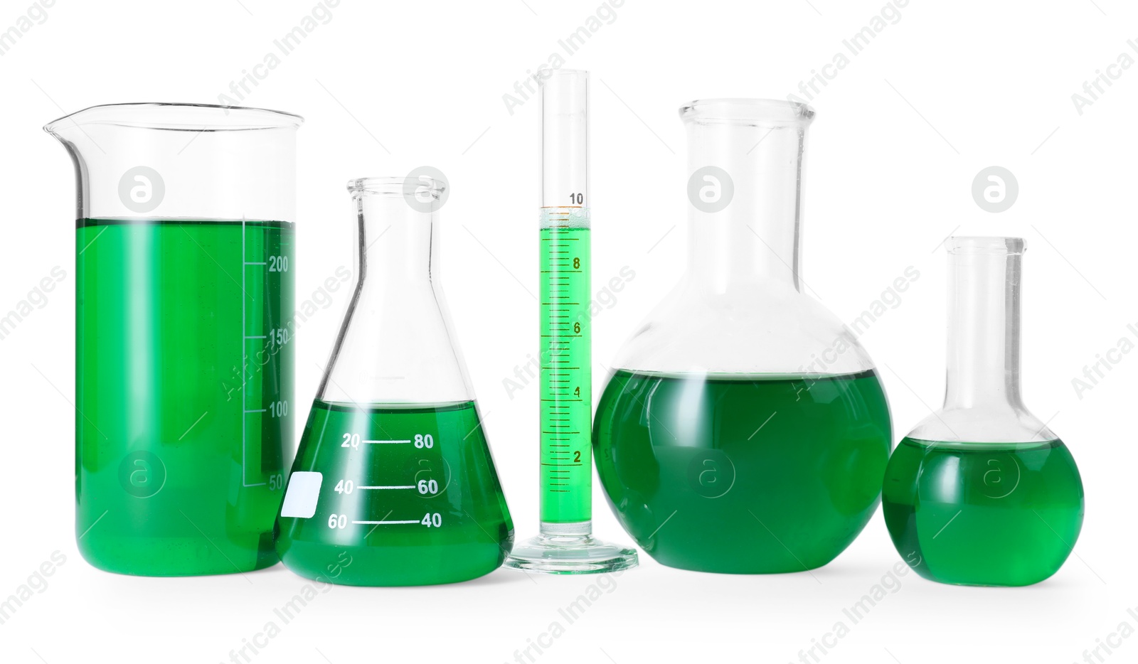 Photo of Different laboratory glassware with green liquid isolated on white