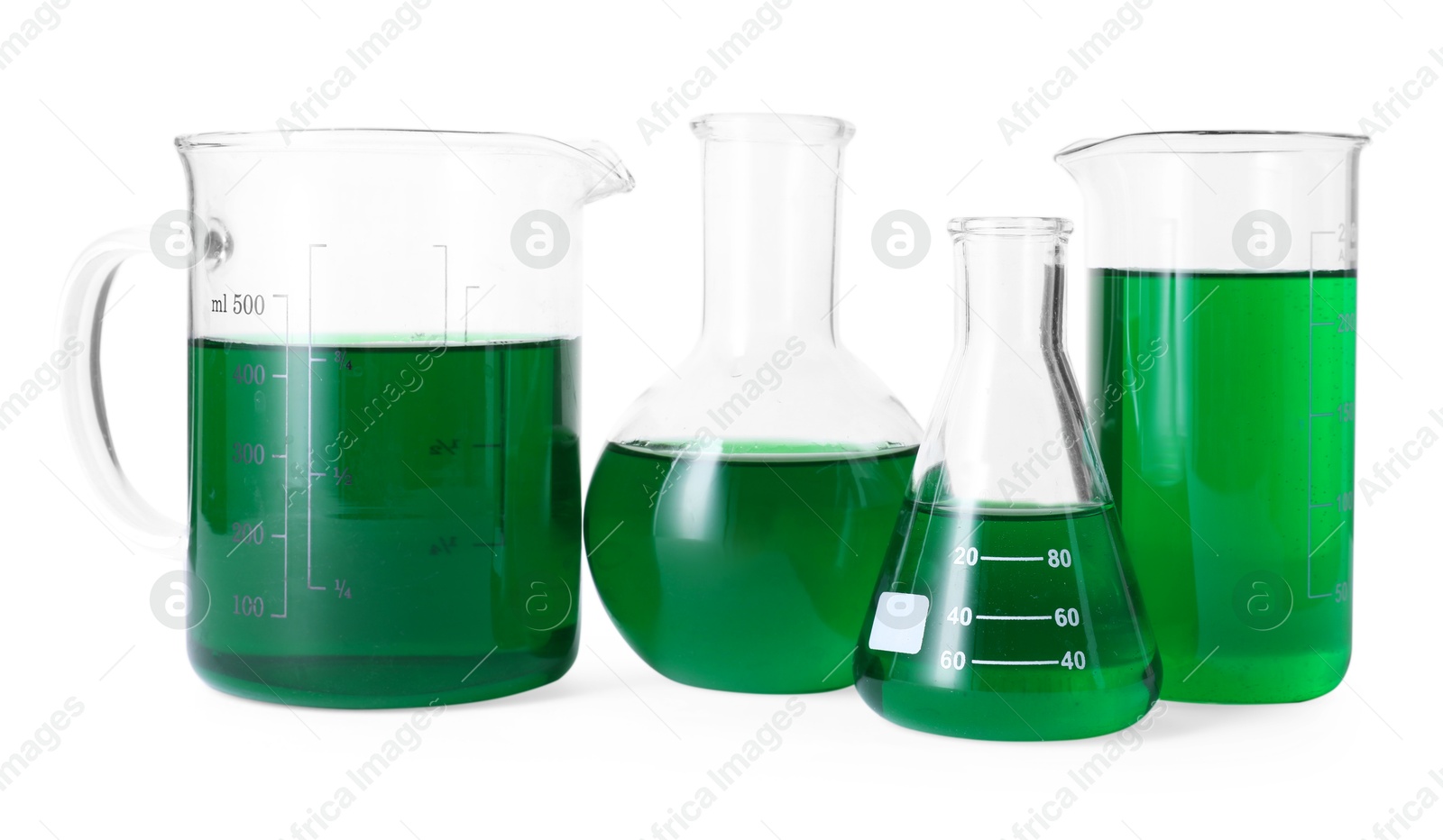 Photo of Different laboratory glassware with green liquid isolated on white