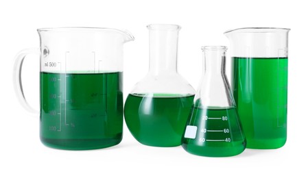Photo of Different laboratory glassware with green liquid isolated on white