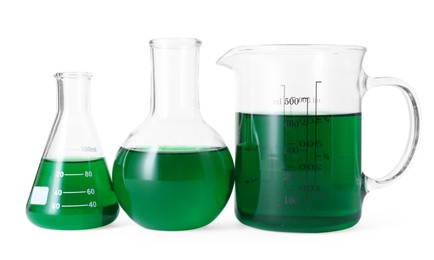 Photo of Different laboratory glassware with green liquid isolated on white