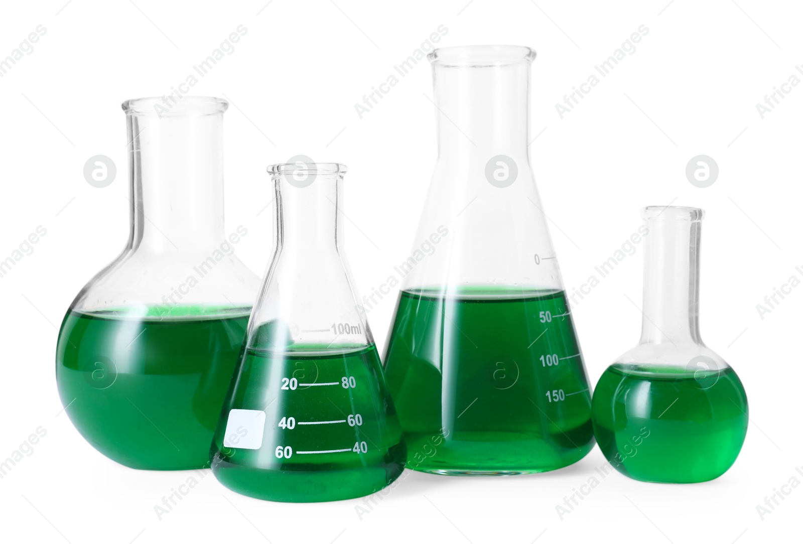 Photo of Different laboratory glassware with green liquid isolated on white