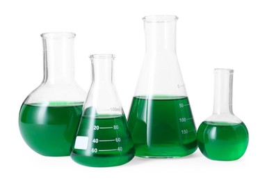 Photo of Different laboratory glassware with green liquid isolated on white