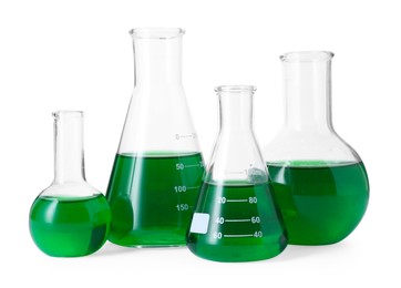 Photo of Different laboratory glassware with green liquid isolated on white