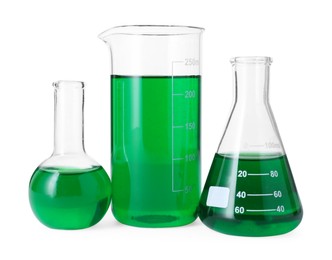 Photo of Different laboratory glassware with green liquid isolated on white