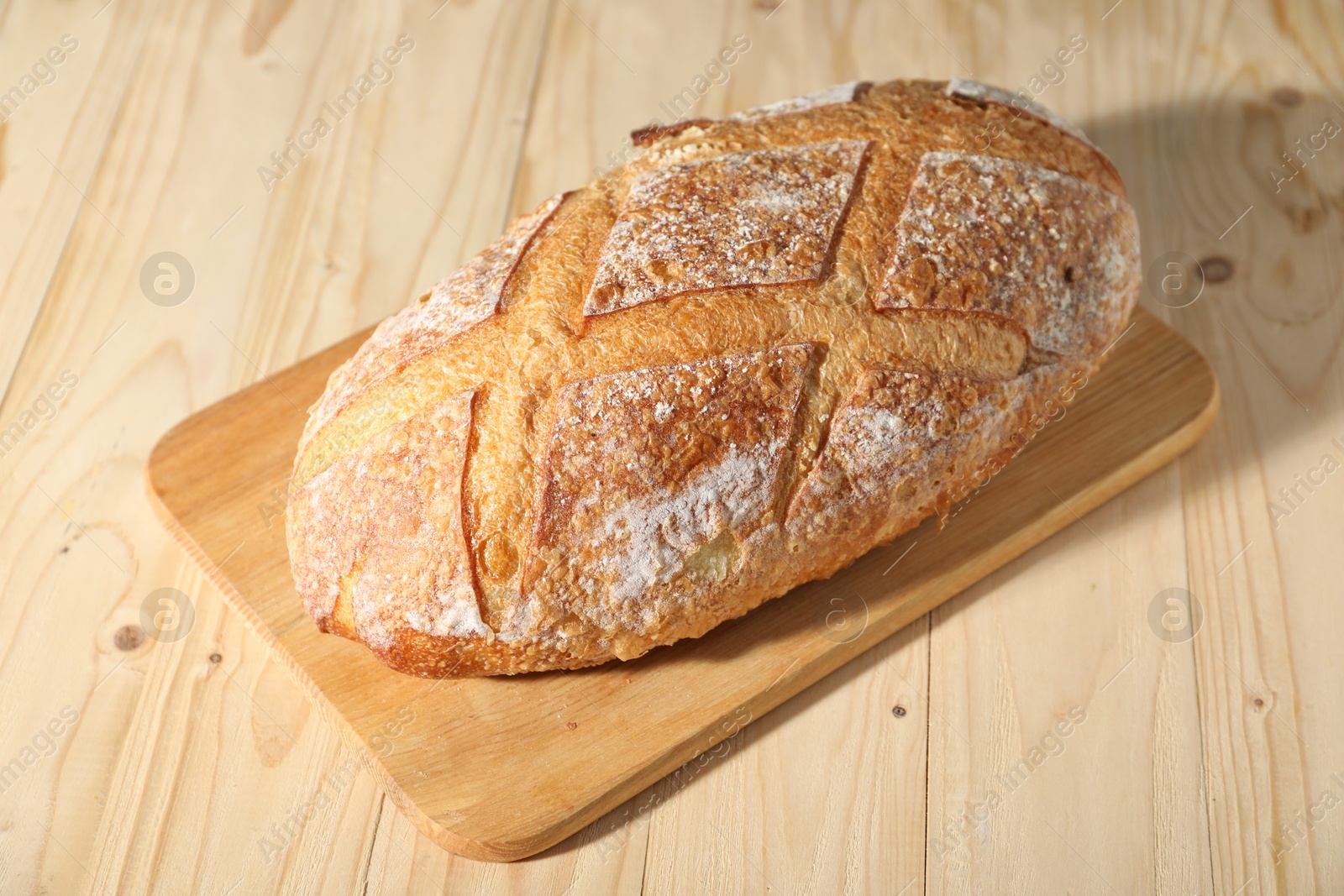 Loaf of fresh bread on light wooden table, closeup Photo of Loaf of fresh bread on light wooden table, closeup