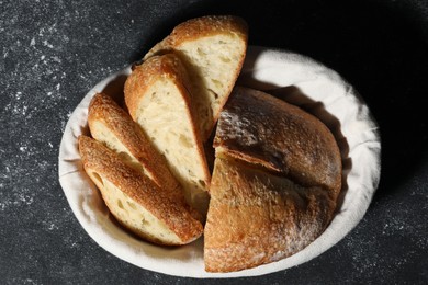 Photo of Fresh cut bread on grey textured table, top view