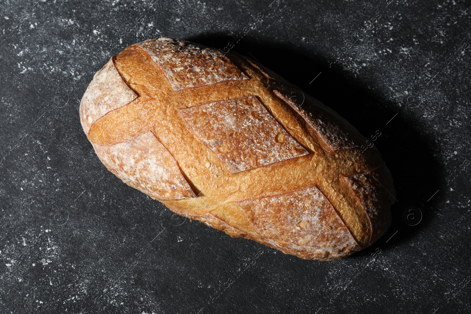 Loaf of fresh bread on grey textured table, top view Photo of Loaf of fresh bread on grey textured table, top view