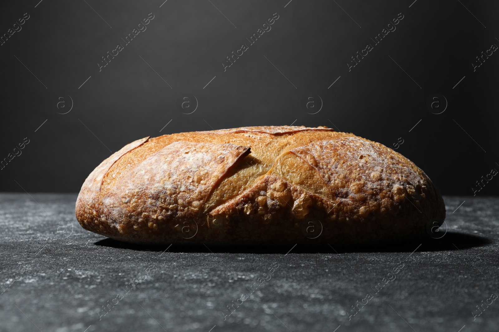 Loaf of fresh bread on grey textured table, closeup Photo of Loaf of fresh bread on grey textured table, closeup