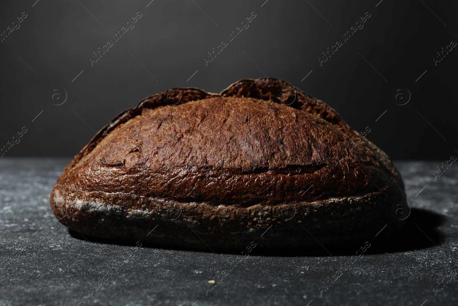 Loaf of fresh bread on grey textured table, closeup Photo of Loaf of fresh bread on grey textured table, closeup