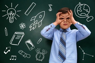 Image of Funny child near green chalkboard with drawings