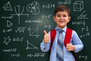 Image of Child showing thumbs-up near green chalkboard with formulas and drawings