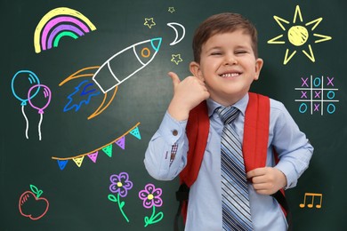 Image of Child showing thumbs-up near green chalkboard with drawings