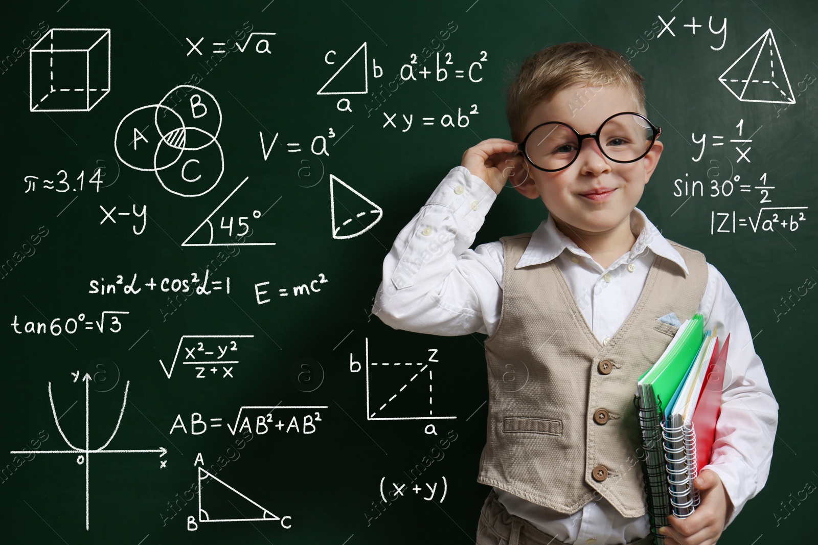 Image of Child wearing eyeglasses near green chalkboard with formulas and drawings