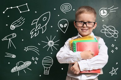 Image of Child wearing eyeglasses near green chalkboard with drawings