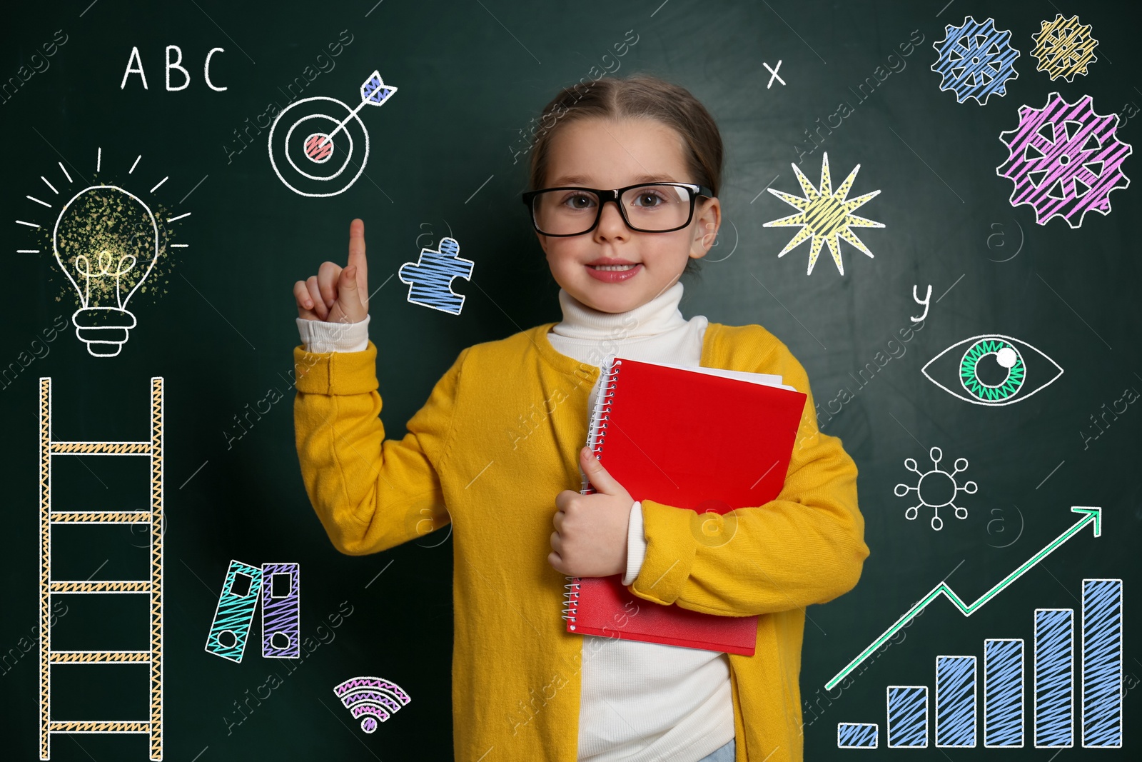 Image of Child pointing at green chalkboard with drawings