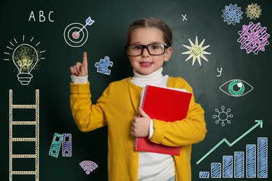 Image of Child pointing at green chalkboard with drawings