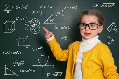 Image of Child pointing at green chalkboard with formulas and drawings