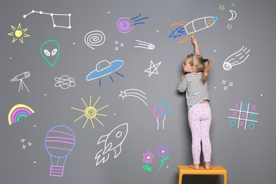 Image of Little child drawing on grey background with chalk