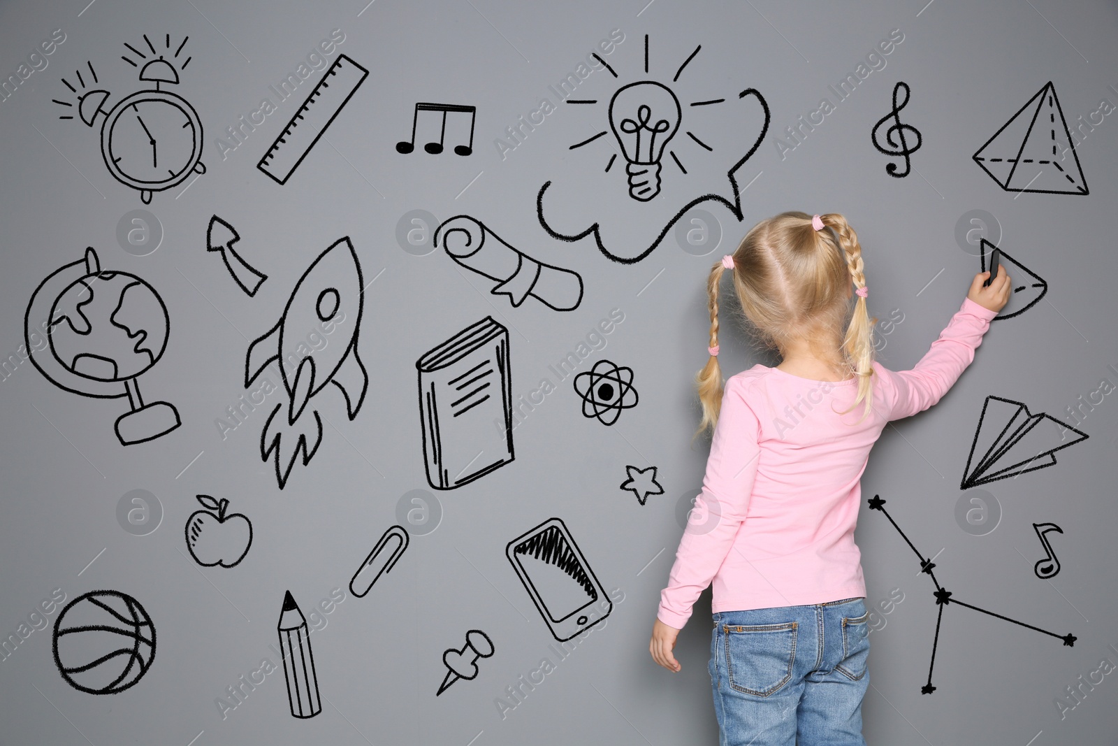 Image of Little child drawing on grey background with chalk, back view