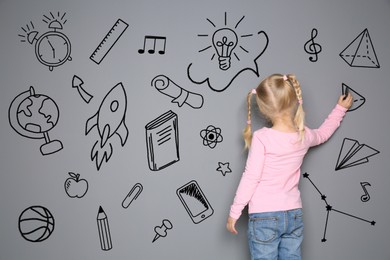 Image of Little child drawing on grey background with chalk, back view