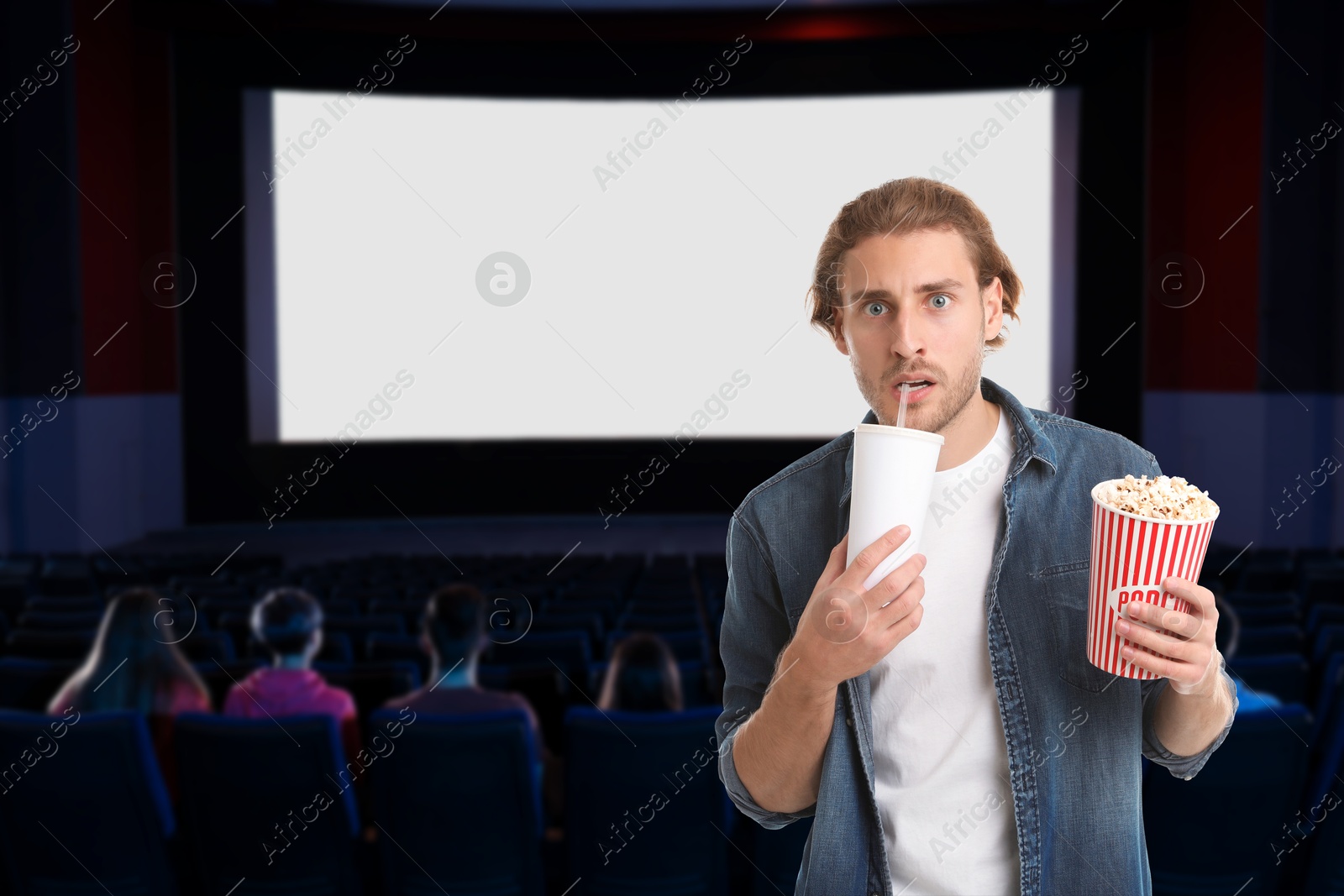 Image of Man with beverage and popcorn in cinema