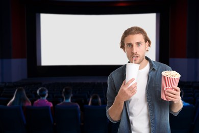 Image of Man with beverage and popcorn in cinema
