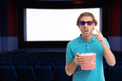 Image of Emotional man with 3D glasses and popcorn in cinema