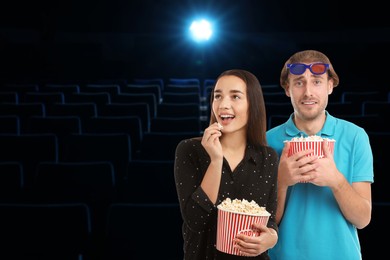 Image of Couple with buckets of popcorn in dark cinema