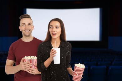 Image of Couple with buckets of popcorn in dark cinema