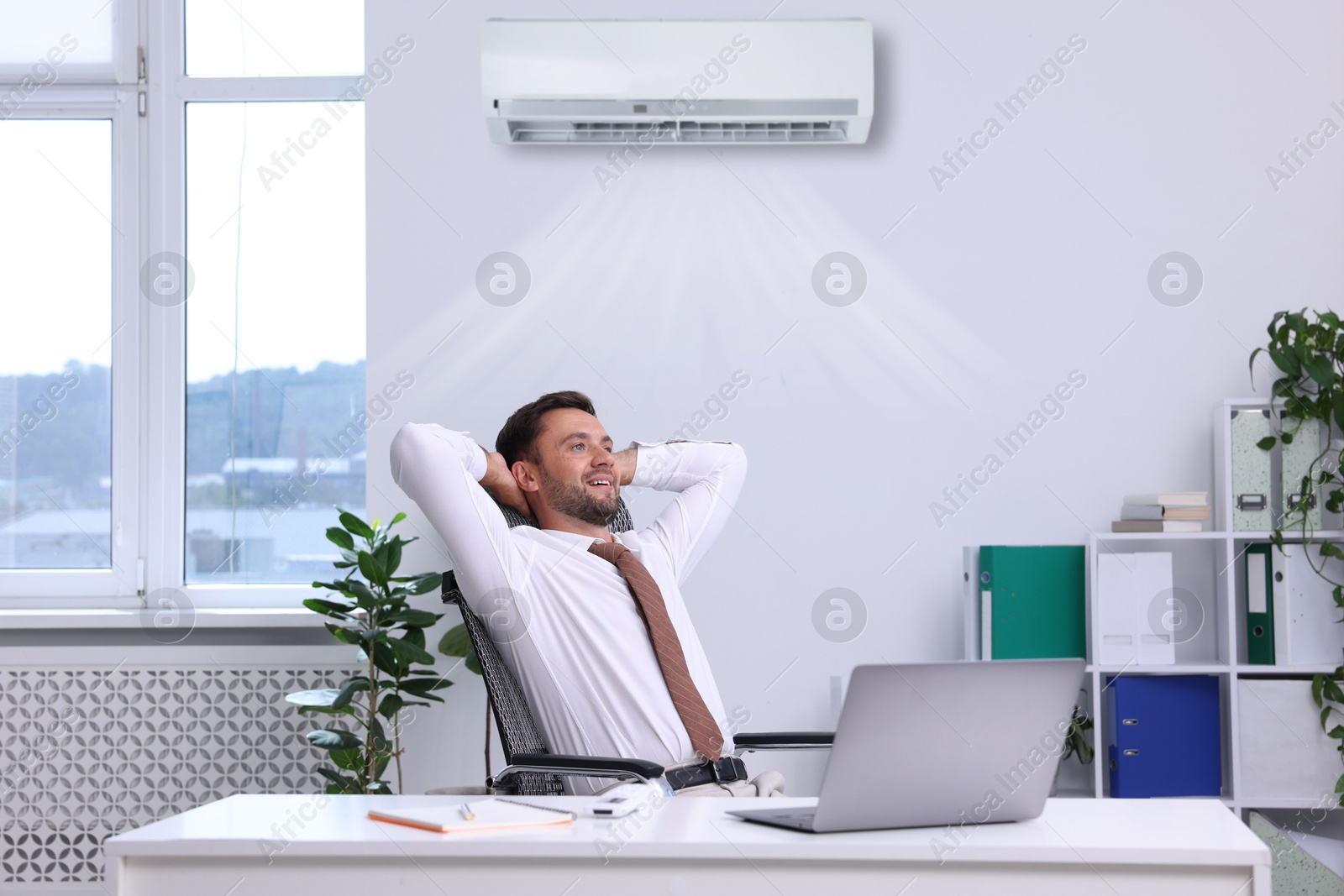 Image of Worker under air conditioner in office. Keeping comfortable temperature