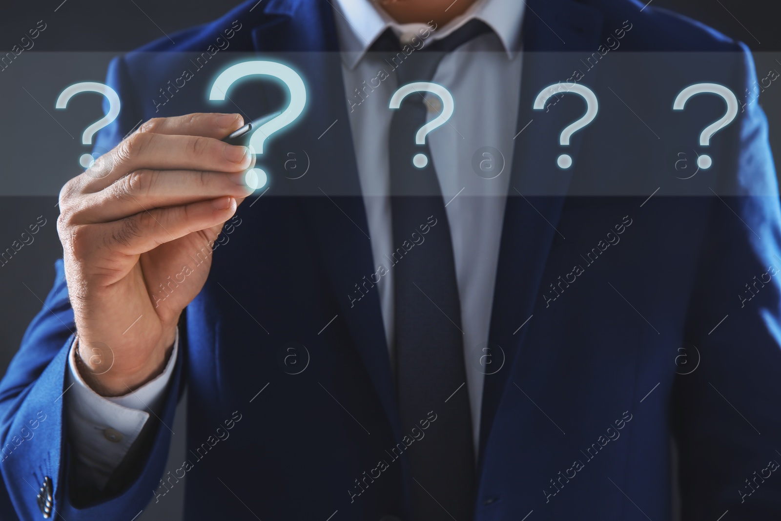 Image of Businessman touching question mark on virtual screen against dark background, closeup