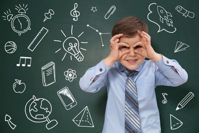 Image of Funny child near green chalkboard with drawings