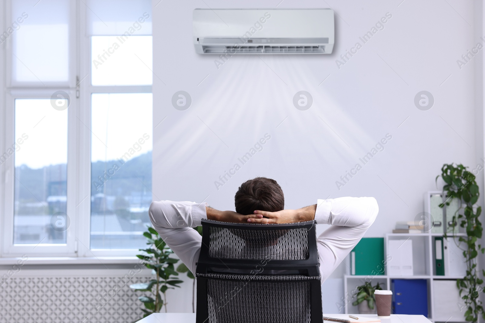 Image of Worker under air conditioner in office. Keeping comfortable temperature