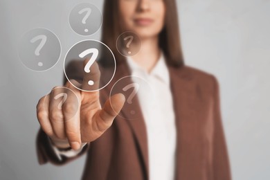 Image of Business woman touching question mark on virtual screen against grey background, closeup