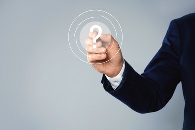 Image of Businessman touching question mark on virtual screen against grey background, closeup