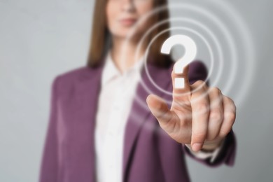 Image of Business woman touching question mark on virtual screen against grey background, closeup