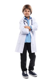 Photo of Choice of profession. Little boy in uniform with stethoscope pretending to be doctor on white background