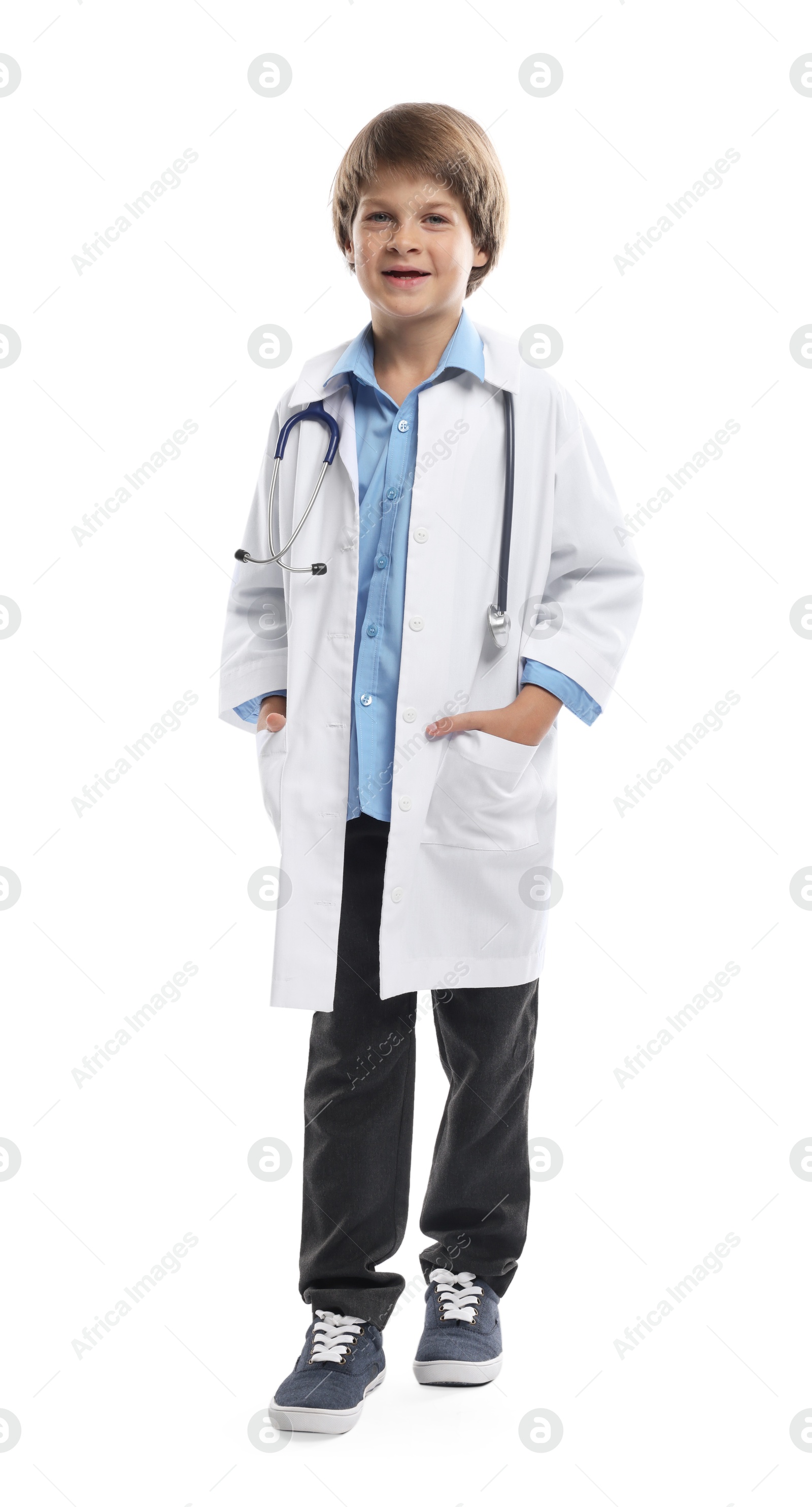 Photo of Choice of profession. Little boy in uniform with stethoscope pretending to be doctor on white background