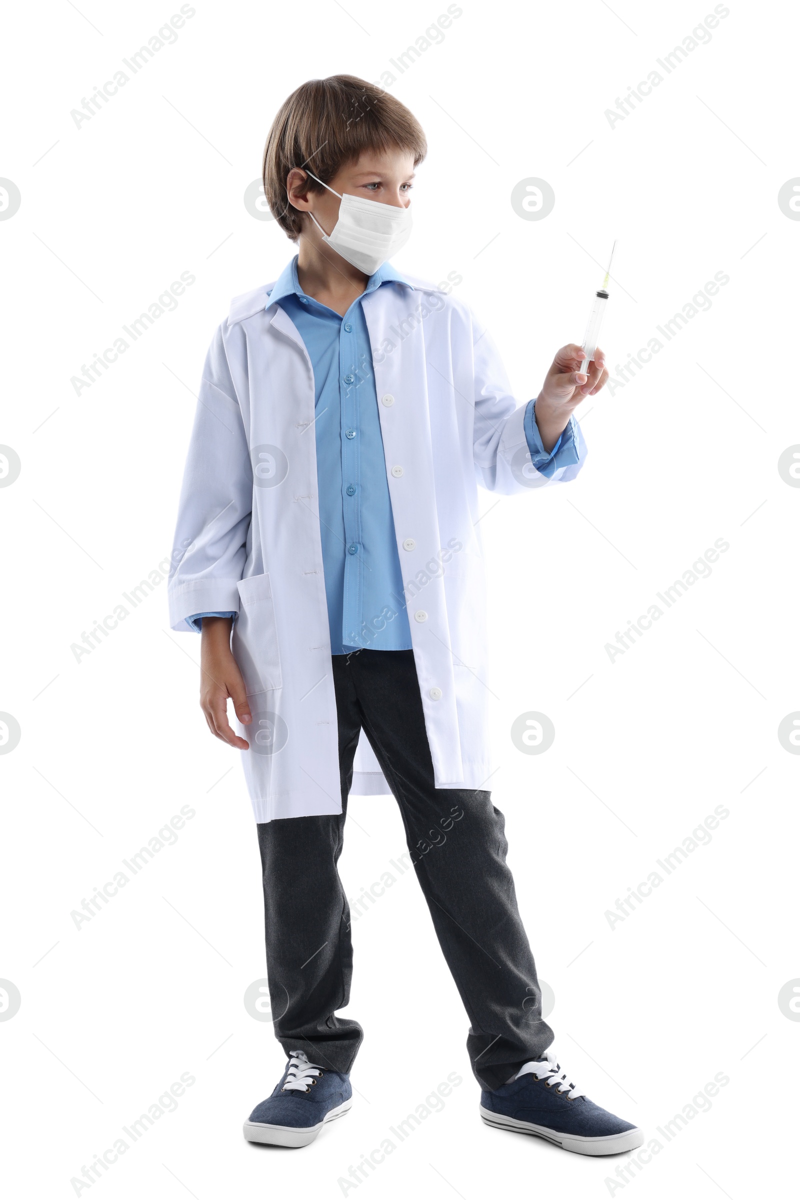 Photo of Choice of profession. Little boy in medical mask with syringe pretending to be doctor on white background