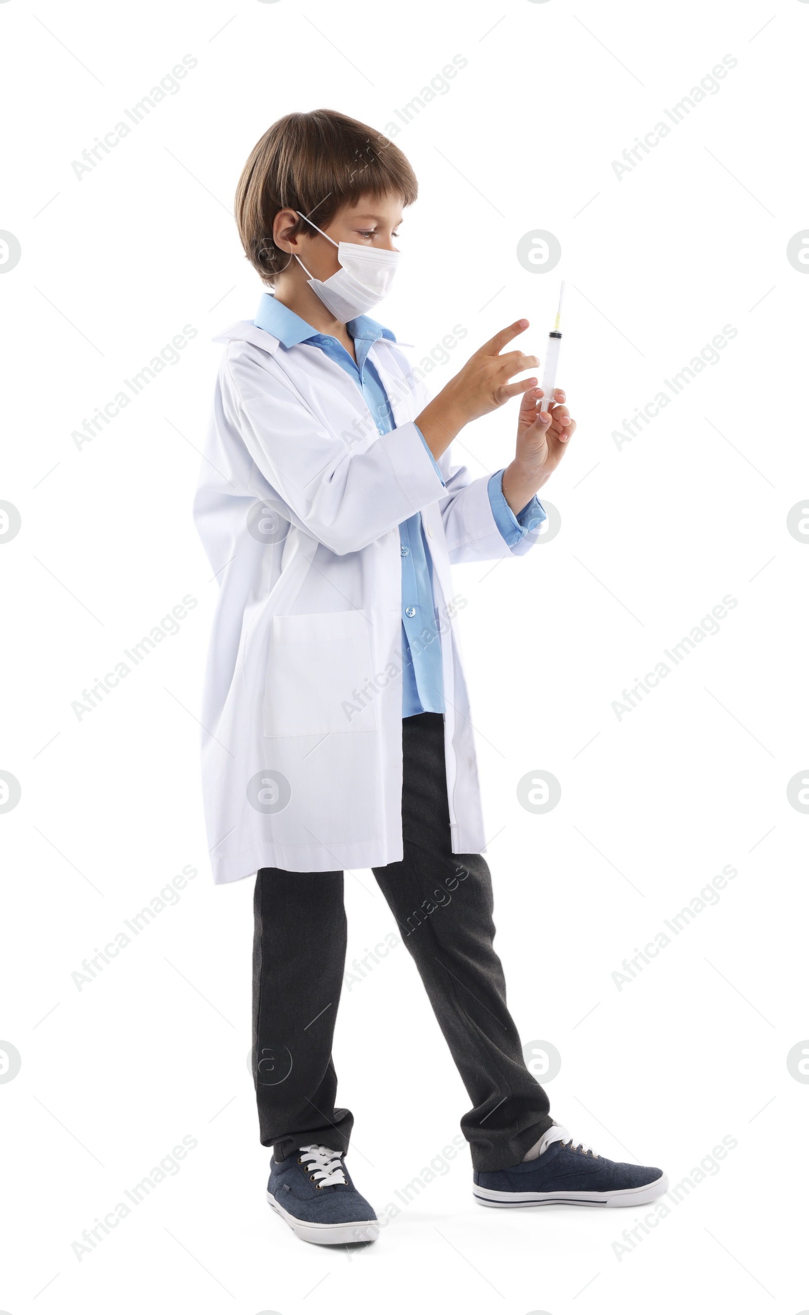 Photo of Choice of profession. Little boy in medical mask with syringe pretending to be doctor on white background